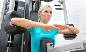 Eine Frau führt auf einem Fitnessgerät eine Sit-up-Übung durch, um ihre Bauchmuskeln zu trainieren.