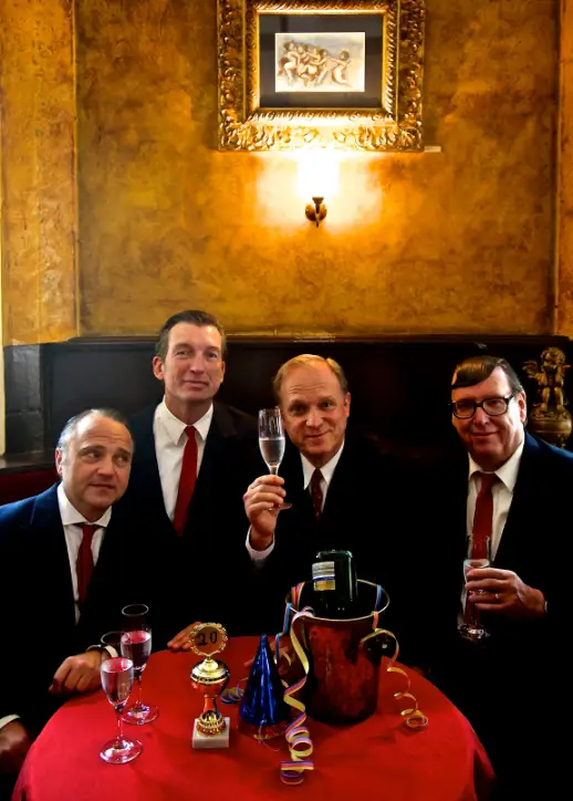 Ulrich Tukur & die Rhythmus Boys in Anzügen heben ihre Weingläser.