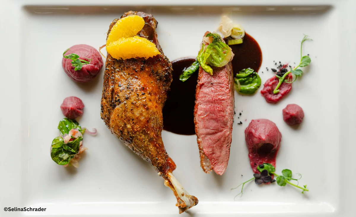 Ein Teller mit einer Ente und verschiedenen Gemüsebeilagen aus der Ganymed Brasserie.