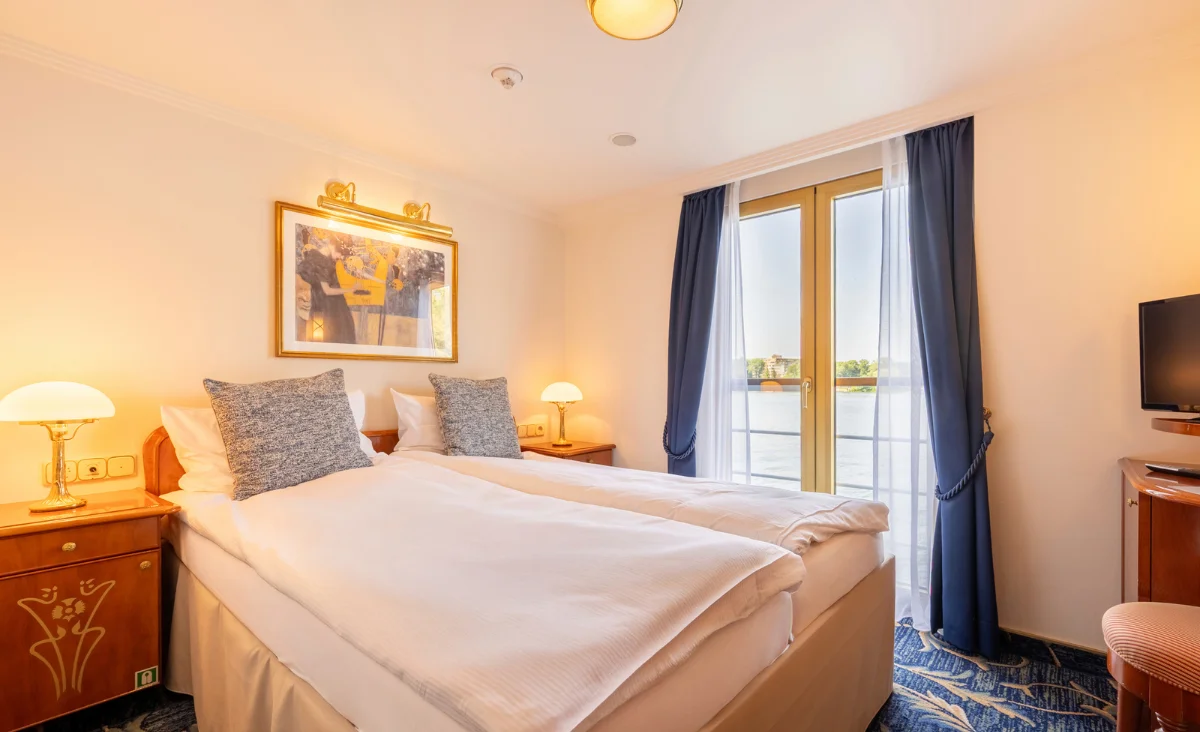 Foto einer Kabine an Bord der MS Thurgau Chopin mit einem Bett und einer Couch, ideal für eine romantische 8-tägige Flusskreuzfahrt für zwei.