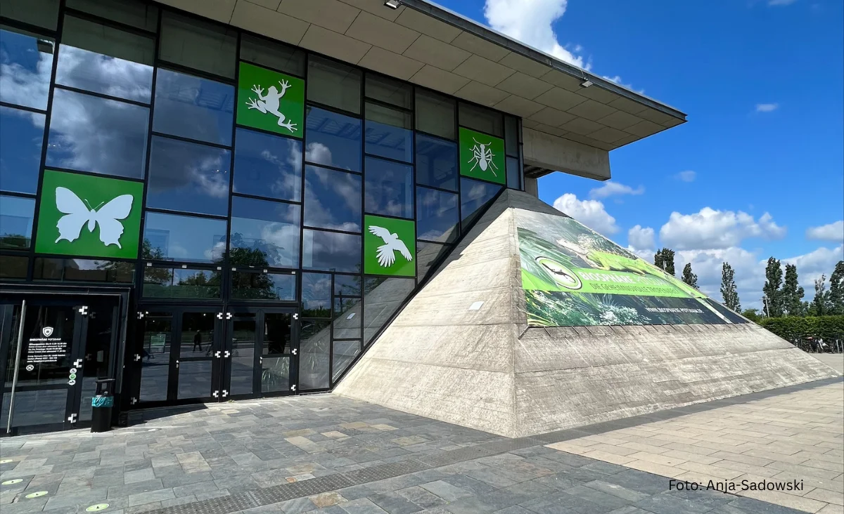 Ansicht eines Gebäudes mit grünen und weißen Schildern, das die Biosphäre Potsdam repräsentiert.