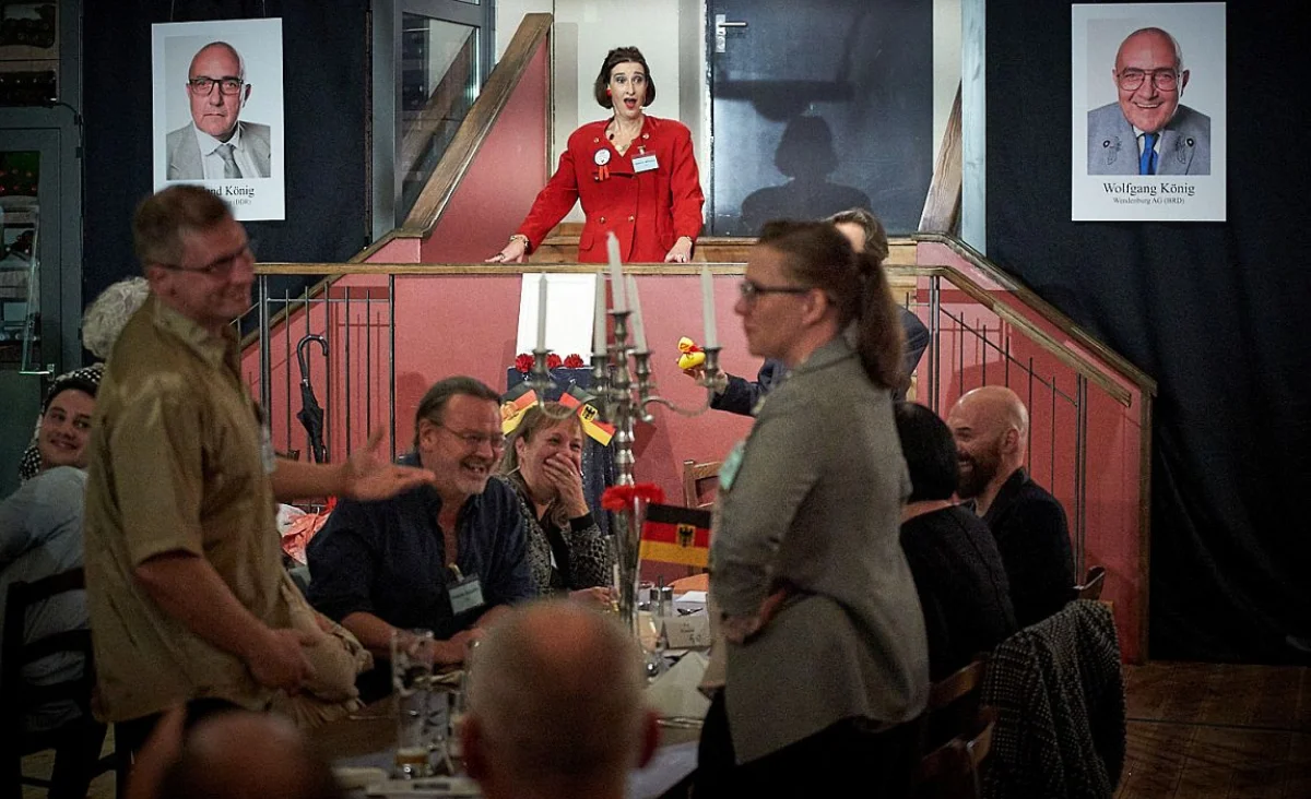 Menschen sitzen an Tischen, während eine Frau vor ihnen steht und ein Dinner-Krimi im Restaurant Habel am Reichstag leitet.
