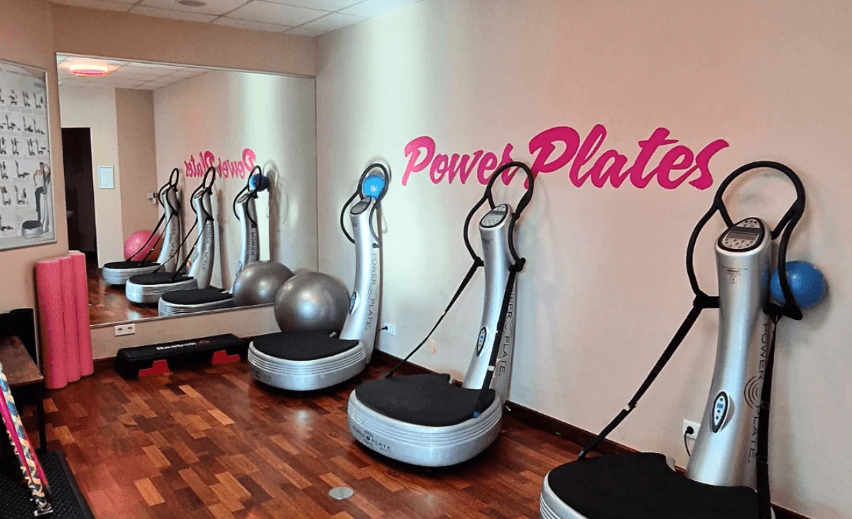 Raum mit Gymnastikgeräten und einem Schild an der Wand mit der Aufschrift "Power Plates".