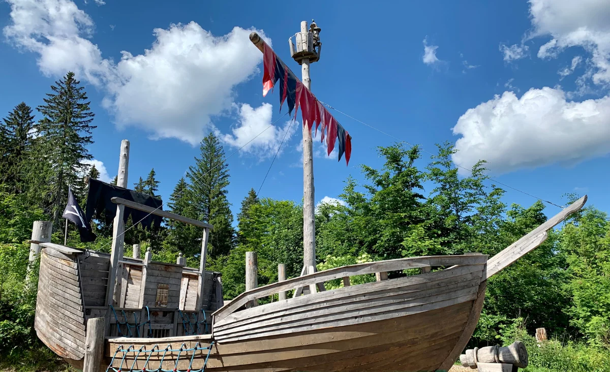 Ein hölzernes Boot steht auf dem Sandboden in der Wurzelrudis Erlebniswelt.