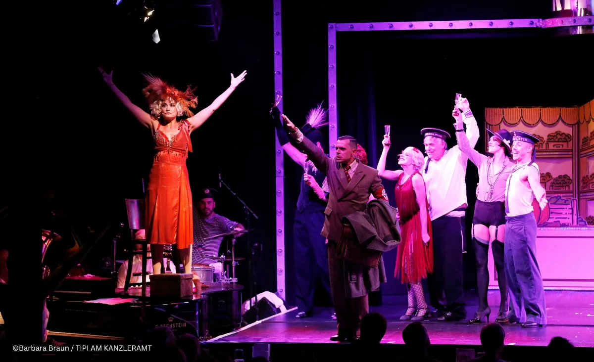 Bühnenbild aus dem Musical »Cabaret Berlin! – das Berlin Musical« mit einer Gruppe von Darstellerinnen und Darstellern in farbenfrohen Kostümen.