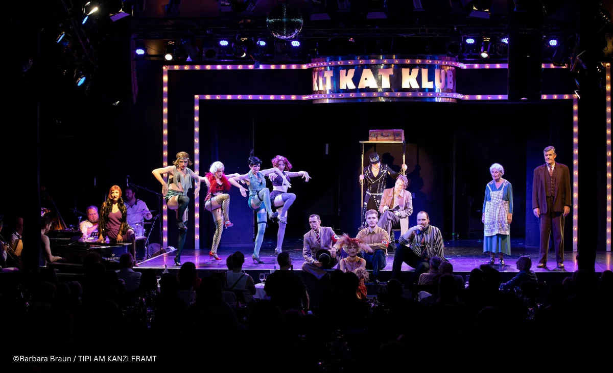 Bühnenbild aus dem Musical »Cabaret Berlin! – das Berlin Musical« mit einer Gruppe von Darstellerinnen und Darstellern in farbenfrohen, teils glitzernden Kostümen.
