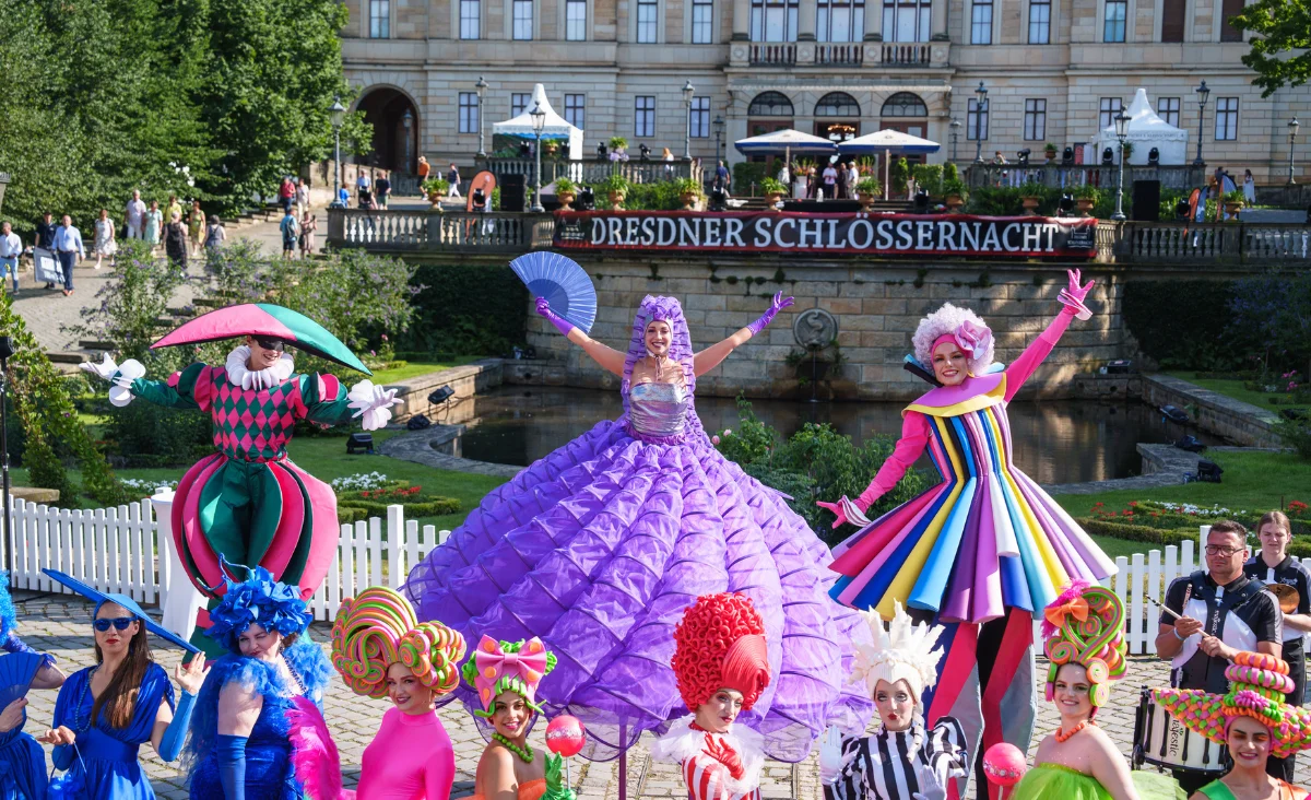 Farbenfroh kostümierte Künstler und Stelzenläufer bei der Dresdner Schlössernacht vor Schloss Albrechtsberg in Dresden.