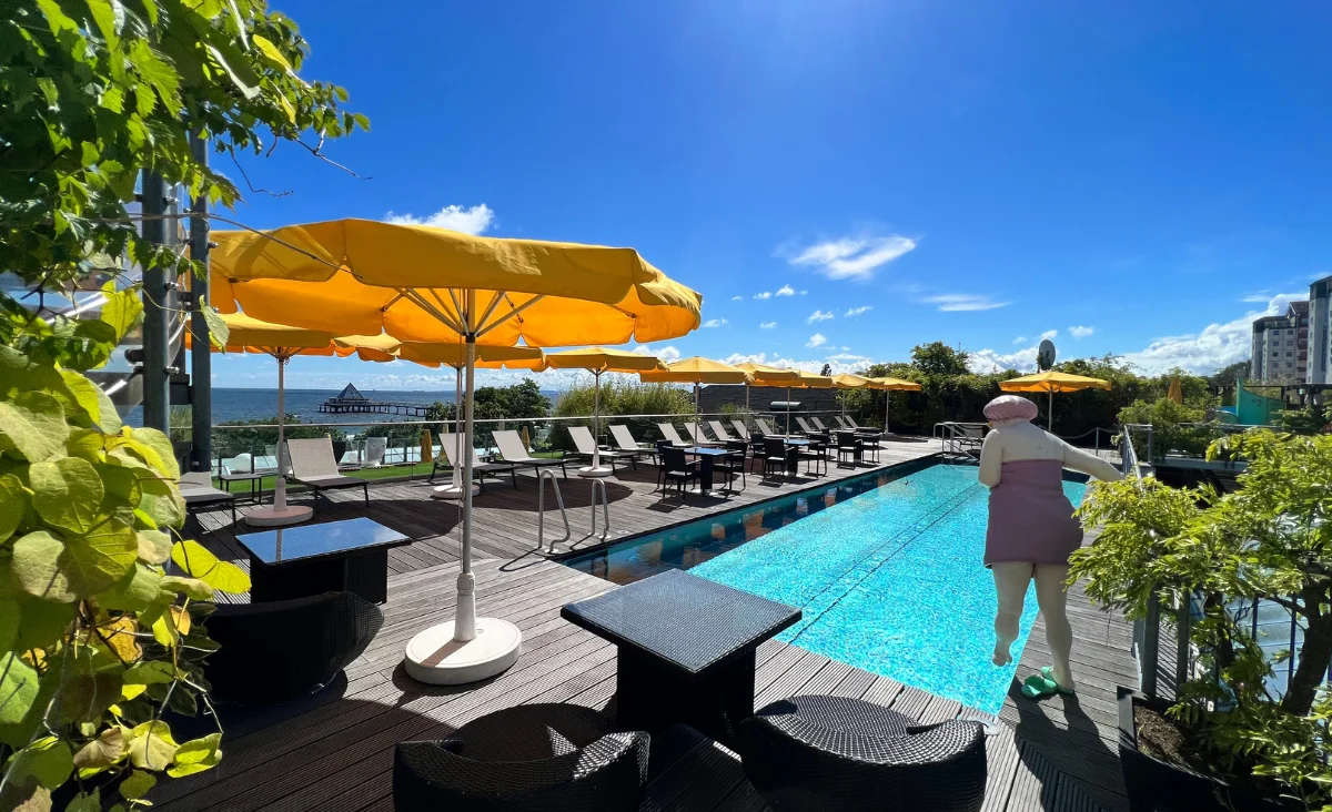 Poolbereich mit Liegestühlen und gelben Sonnenschirmen am Hotel Kaiserhof Heringsdorf bei sonnigem Wetter