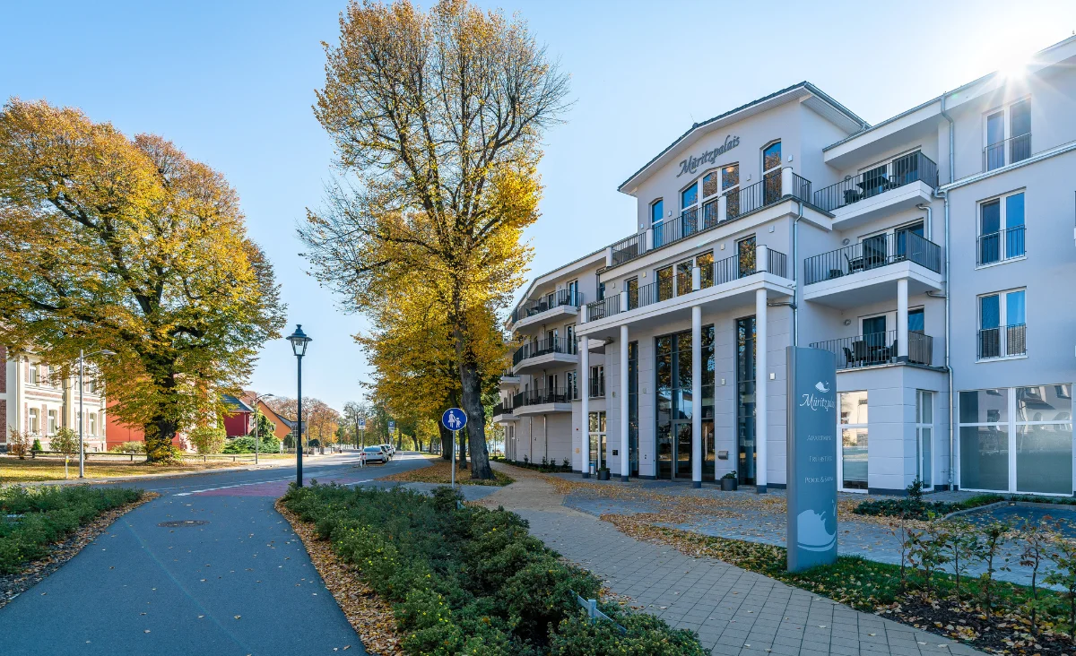 Fassade des Aparthotels Müritzpalais in Waren an der Müritz umgeben von Bäumen
