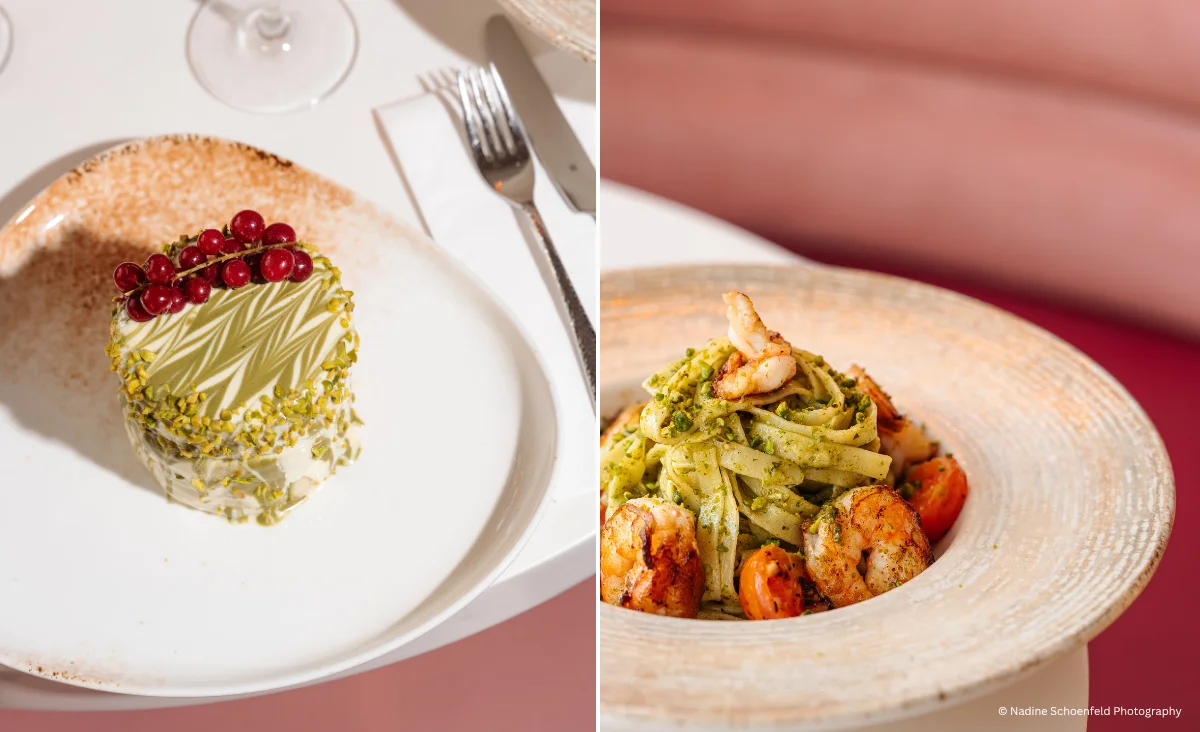 Links eine runde Torte mit grüner Glasur und roten Johannisbeeren auf weißem Teller, rechts ein Teller mit Pasta, Garnelen und grünem Pesto auf hellem Teller vor rosa Hintergrund.