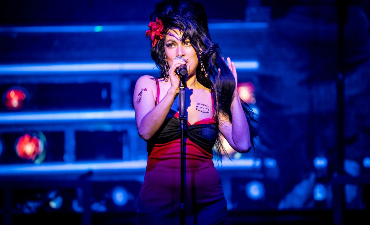 Sängerin mit hochgestecktem Haar und schwarzem Kleid hält Mikrofon auf einer Bühne vor Publikum bei einer Amy-Winehouse-Tribute-Show im Estrel Showtheater Berlin.