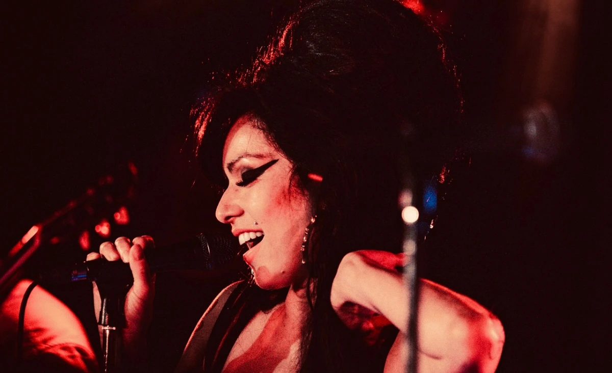 Sängerin mit hochgestecktem Haar und schwarzem Kleid hält Mikrofon auf einer Bühne vor Publikum bei einer Amy-Winehouse-Tribute-Show im Estrel Showtheater Berlin.