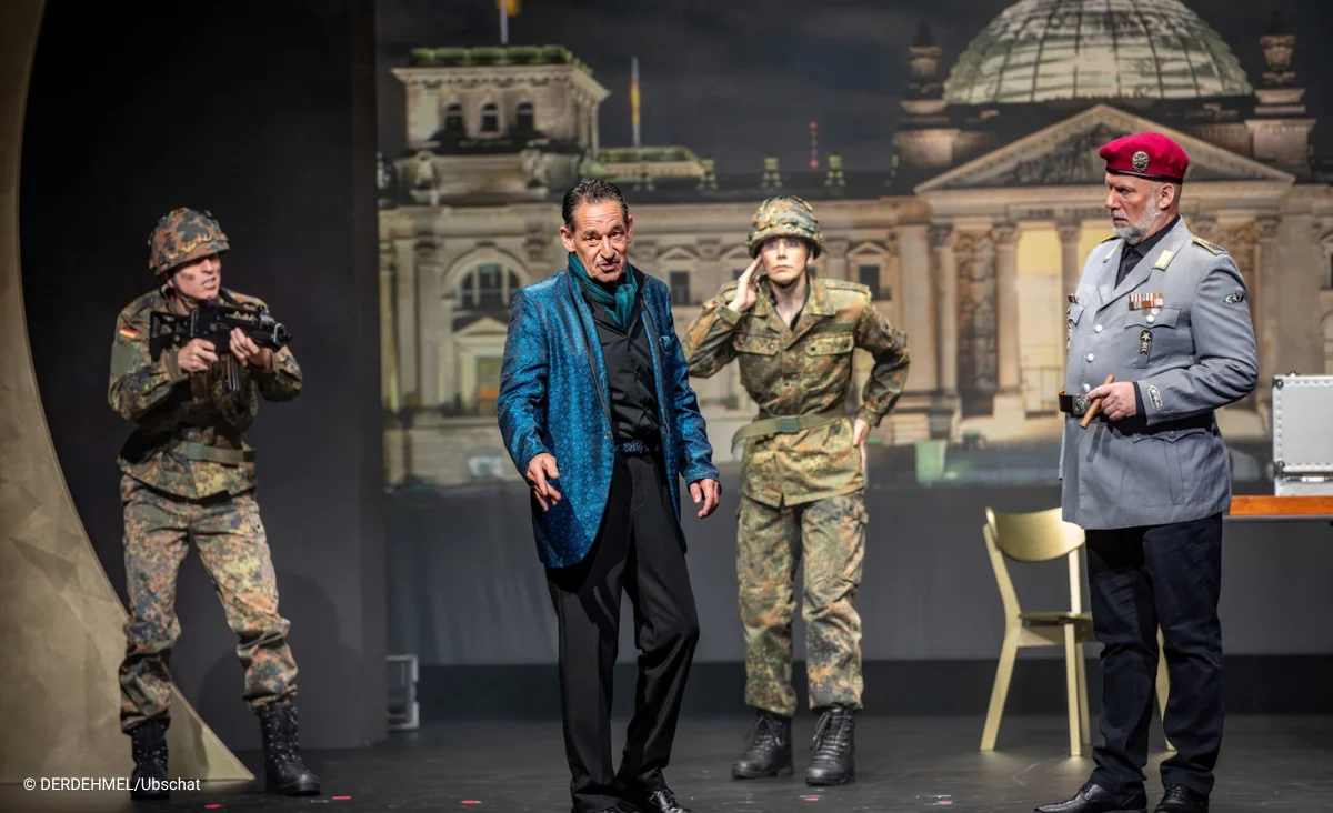 Vier Schauspieler auf einer Bühne vor einer Projektion des Reichstagsgebäudes, in Militäruniform