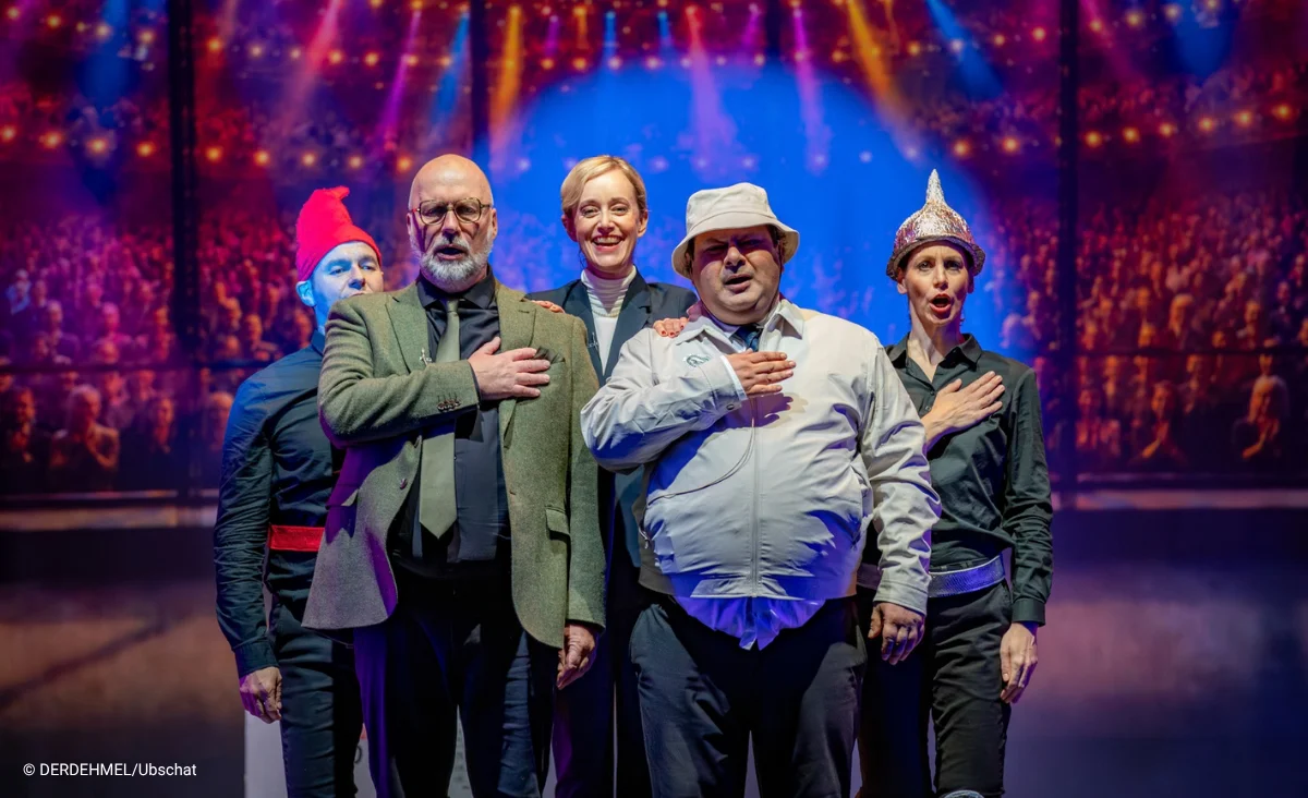 Fünf Schauspieler stehen in einer Reihe, vier mit der rechten Hand auf der Brust. Putsch - Theaterstück im Schlosspartk Theater