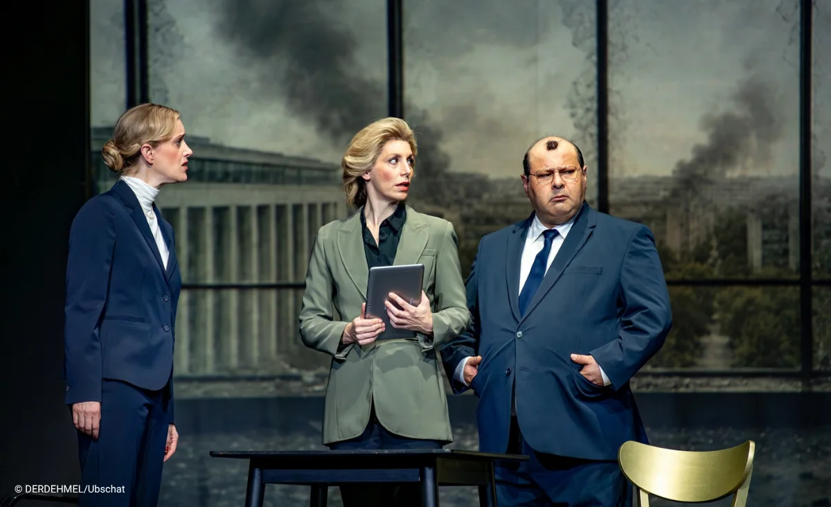 Drei Schauspieler des Putsch Theaterstückes im Schlosspartk Theater in Anzügen stehen eng beieinander