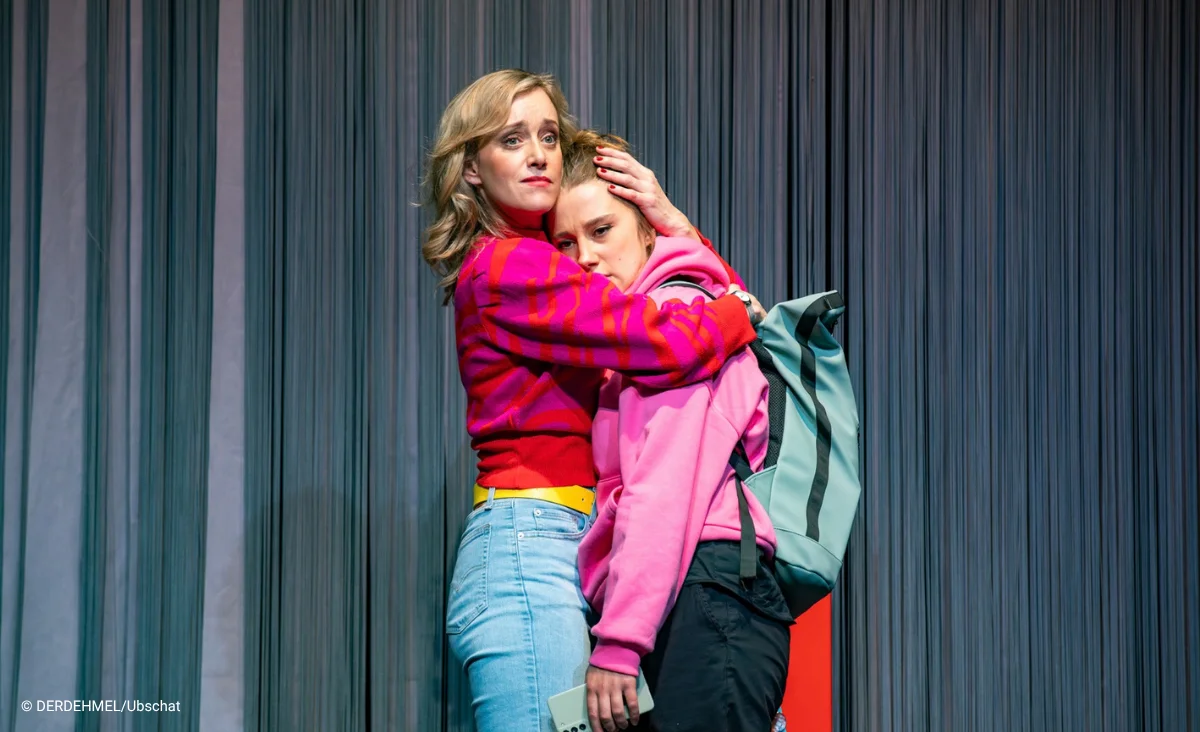 Zwei Schauspielerinnen umarmen sich. Putsch Theaterstück im Schlosspartk Theater