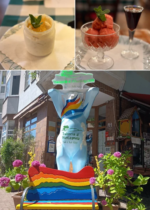 Bunte Bärenfigur mit Regenbogenmuster vor dem Eingang der Trattoria a Muntagnola, umgeben von Blumen und Gebäuden.