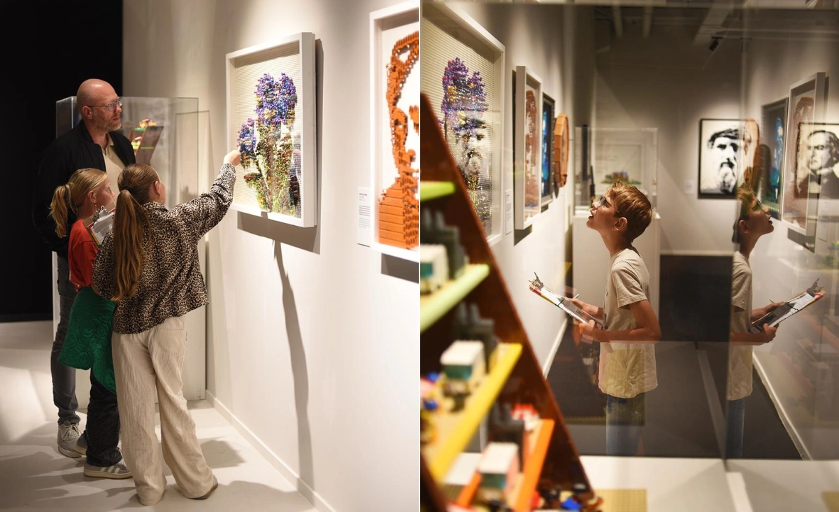 Kinder und ein Erwachsener betrachten und diskutieren detailreiche LEGO-Kunstwerke an weißen Wänden in der Ausstellung Bricks of Wonder Magdeburg