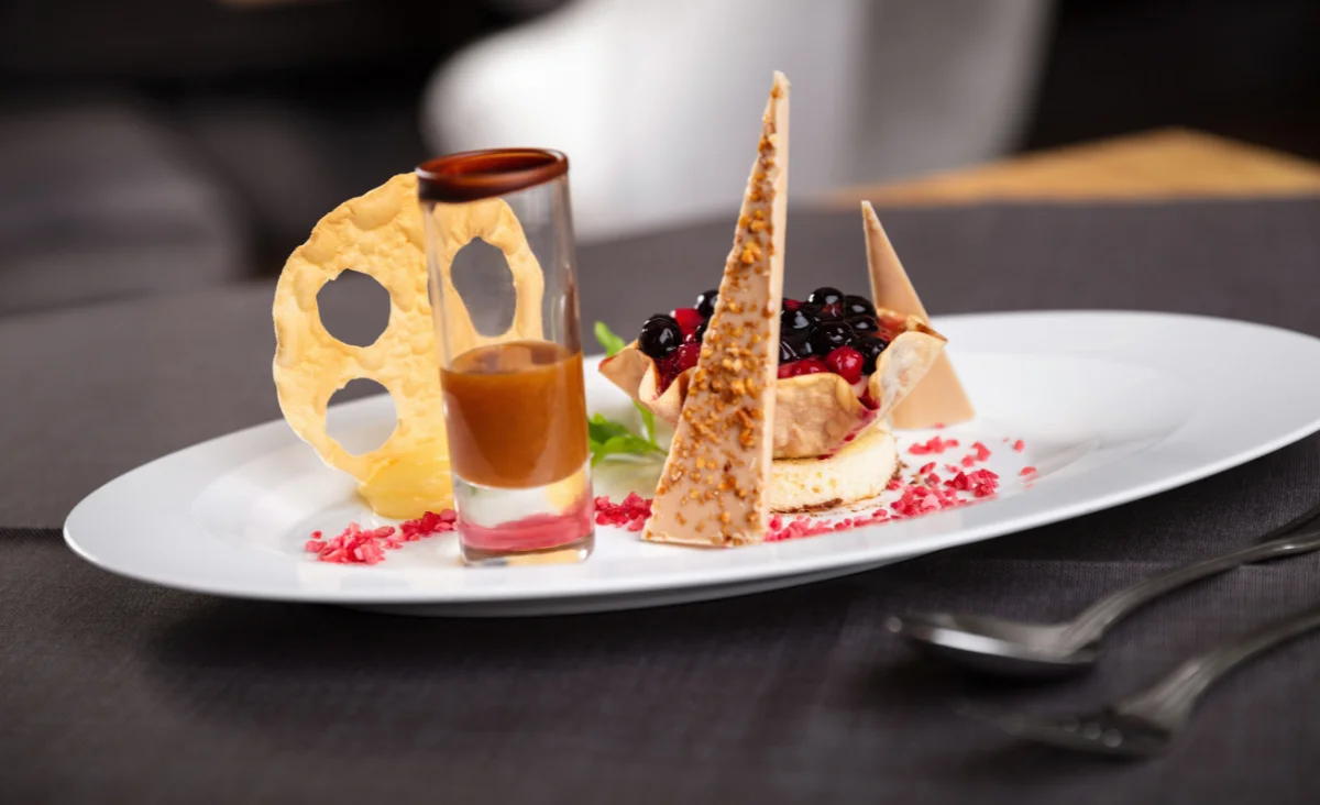 Kunstvoll angerichtetes Dessert im Hotel Bodenmaiser Hof mit Beeren, knuspriger Dekoration und feiner Soße